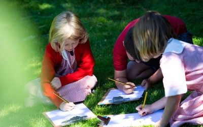 pupils writing in grass