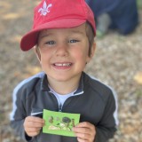 boy smiling holding up his nature finds