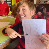 boy holding up a pie chart 