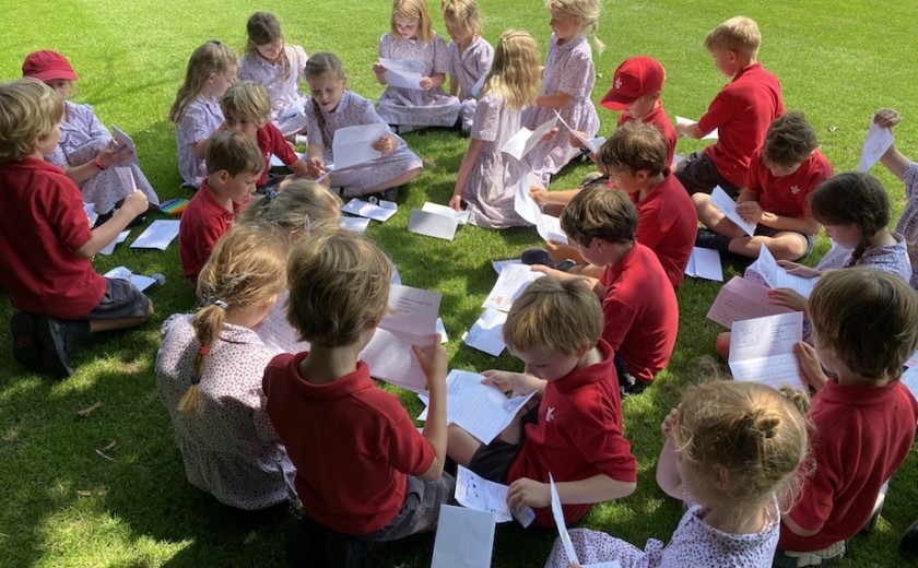 Year 2 sit down to open their buddy letters