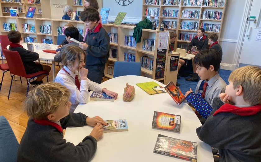 children sat at a table in a libary