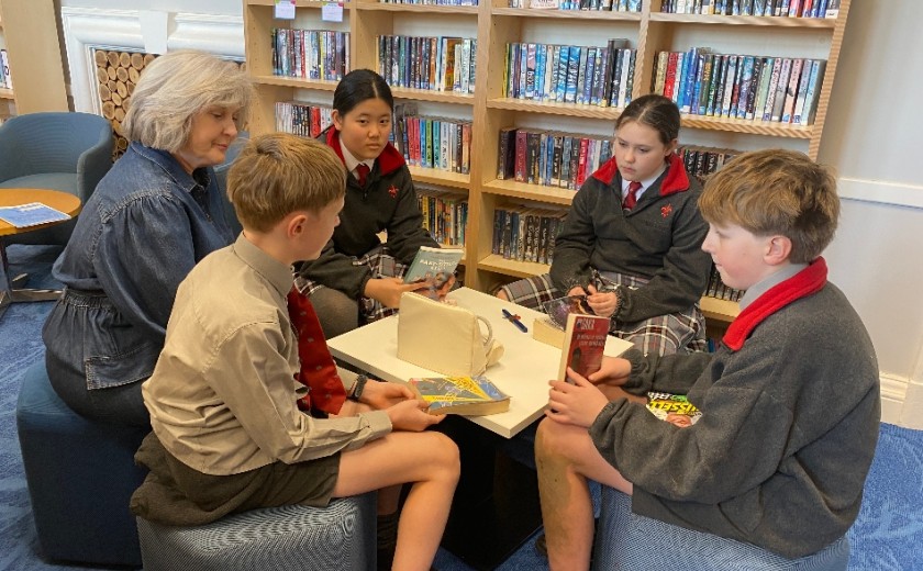 children and teacher gathered around reading