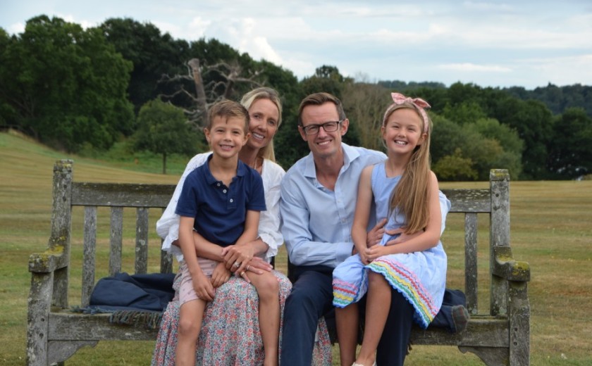 the musson family sit on a bench smiling