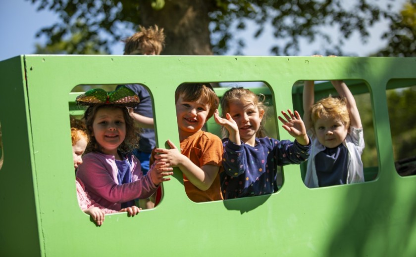children on a play bus in the garden