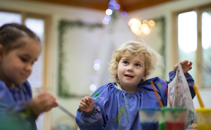 boy holds up painting