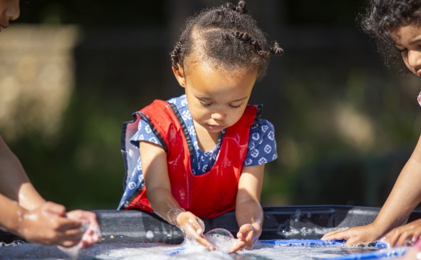 child makes bubbles outside