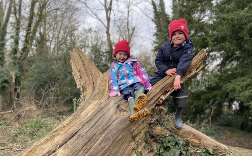 nursery children climb onto log