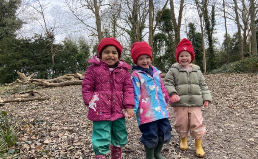 nursery children walking in leaves in the woods