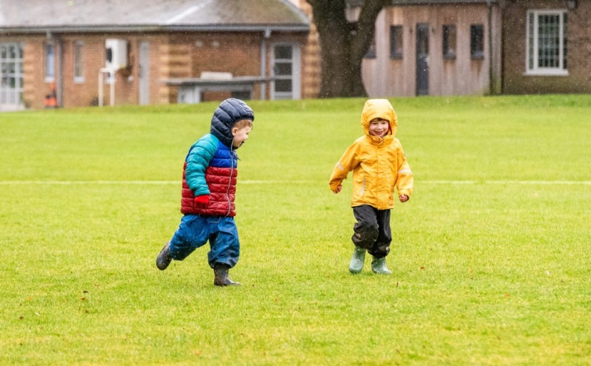 two children run across the grounds away from pre-prep